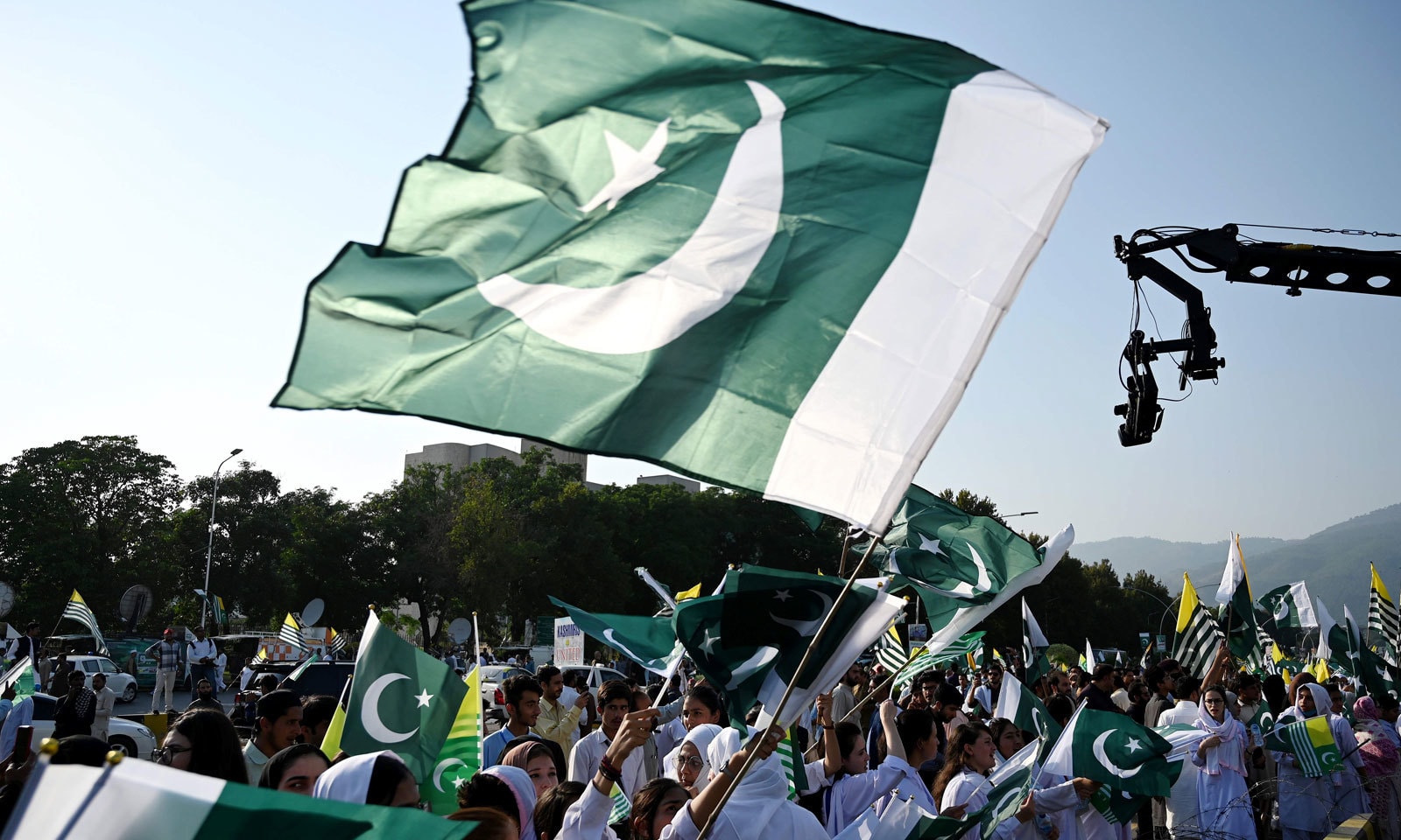 مقبوضہ کشمیر کے عوام سے اظہار یکجہتی کیلئے اسلام آباد میں بنائی گئی انسانی زنجیر میں طلبہ پاکستان اور آزاد کشمیر کے پرچم لہرا رہے ہیں — فوٹو: اے ایف پی