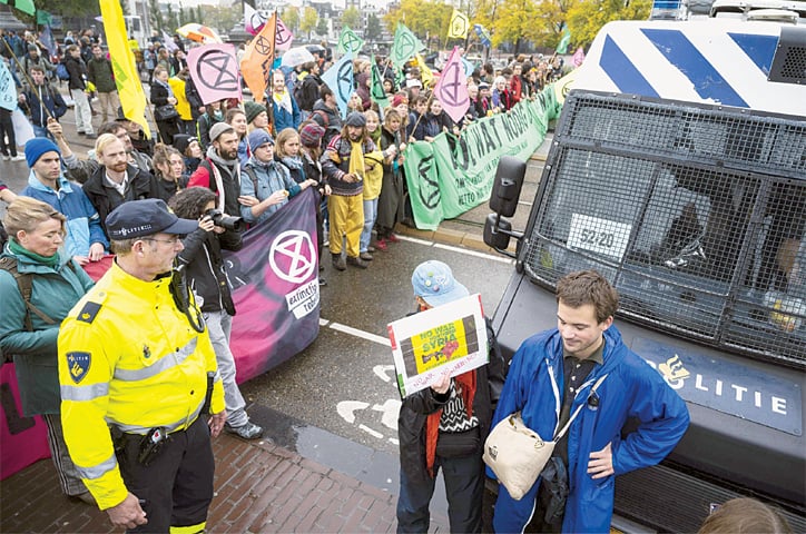 Amsterdam: Activists from the “Extinction Rebellion” climate change action group block the Blauwbrug bridge on Saturday.—AFP