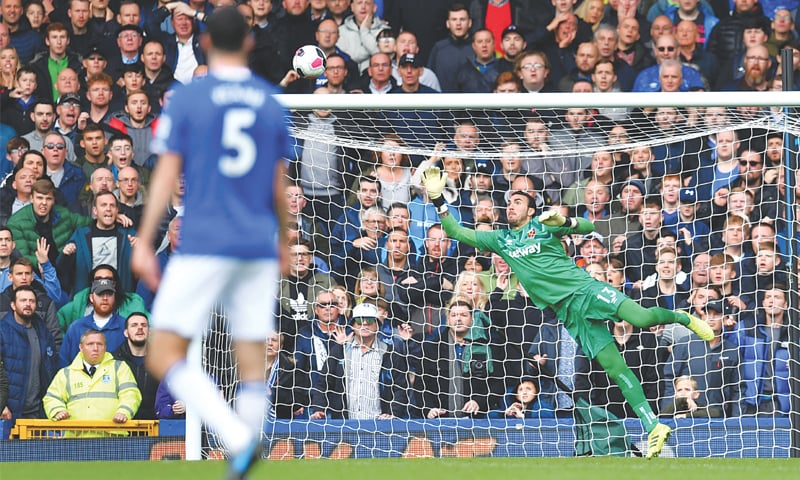 LIVERPOOL: Gylfi Sigurdsson scores Everton&rsquo;s second goal past West Ham United&rsquo;s goalkeeper Roberto during the English Premier League match at Goodison Park on Saturfay.&mdash;AFP