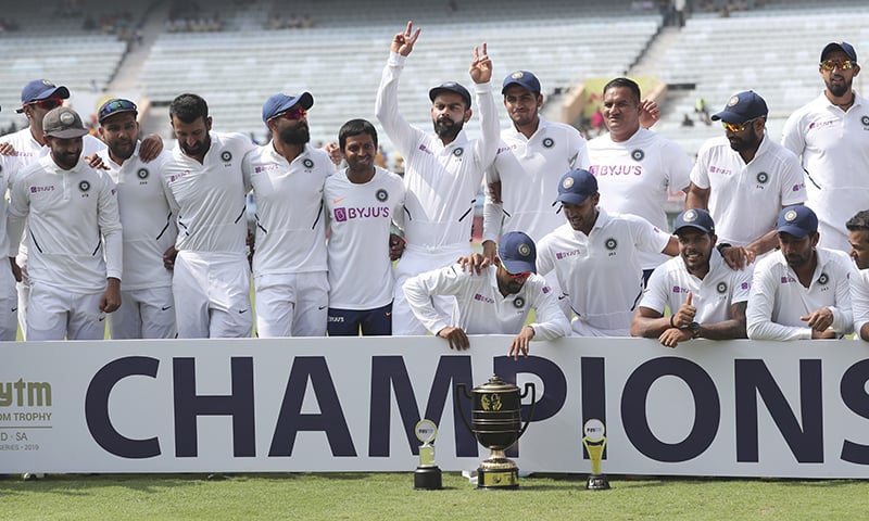 Members of Indian team pose with the winners trophy as captain Virat Kohli flashes victory sign after their win on the fourth day of third and last cricket test match between India and South Africa in Ranchi, India on October 22, 2019. — AP