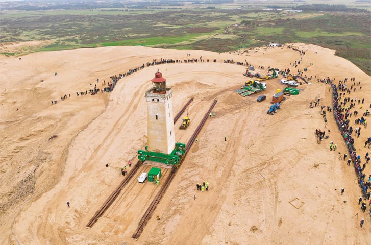 Jutland (Denmark): An aerial shot shows people looking on as the lighthouse is moved away.—AFP