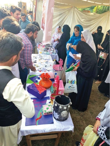 Visitors at a stall at the literary festival in Mardan. &mdash; Dawn