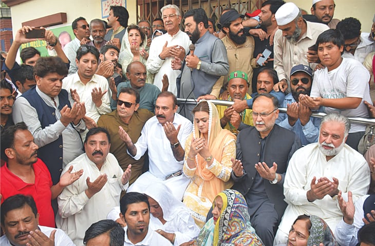 PML-N workers and leaders pray for Nawaz Sharif outside the Services Hospital on Thursday.—Aun Jafri / White Star