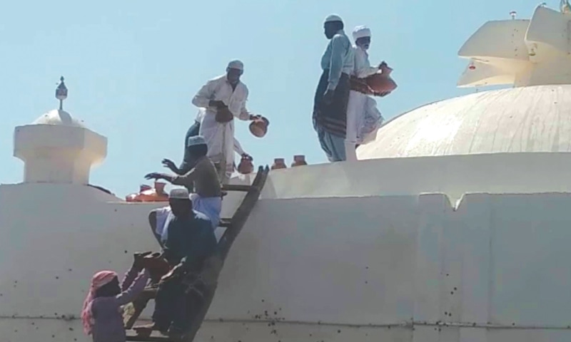 DEVOTEES climb up a dome of the shrine to wash it with milk in centuries-old ritual.&mdash;Dawn