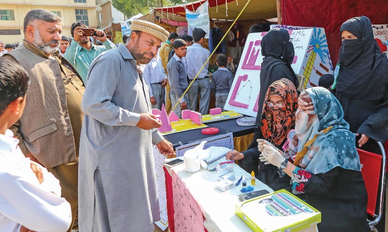 Students conduct blood group test at a stall at the science, arts and cultural exhibition in Mingora on Wednesday. &mdash; Dawn