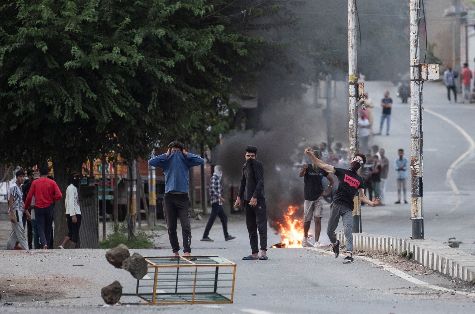 Kashmiri residents throw stones towards Indian security forces during restrictions in Srinagar. — Reuters