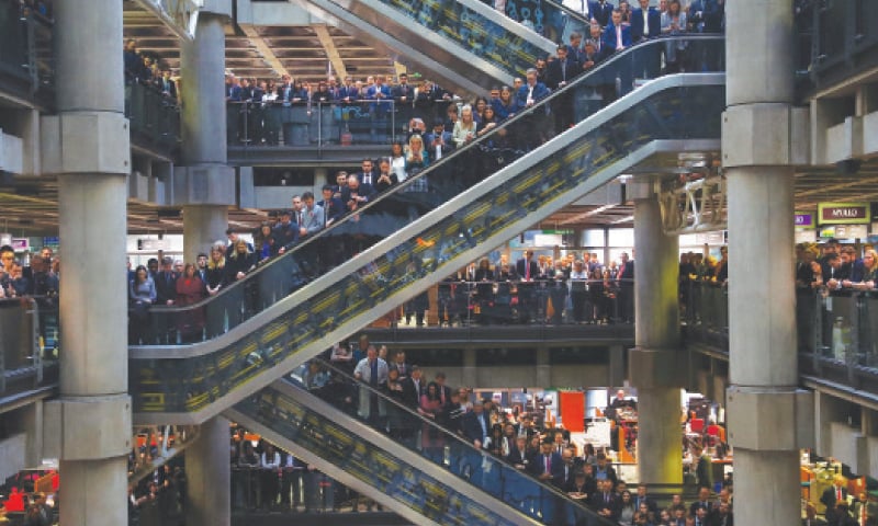 STAFF members stand for a poppy drop during a Remembrance Service at the Lloyd&rsquo;s building in the City of London.&mdash;Reuters