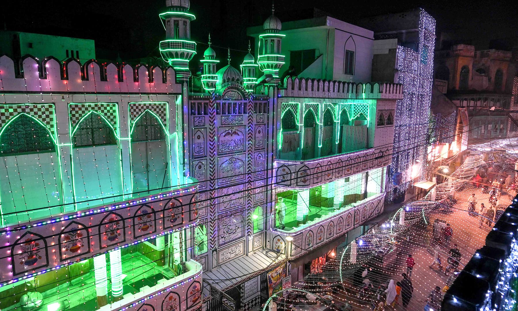 People walk in a street decorated to mark Eid-i-Miladun Nabi in Lahore on Saturday. — AFP