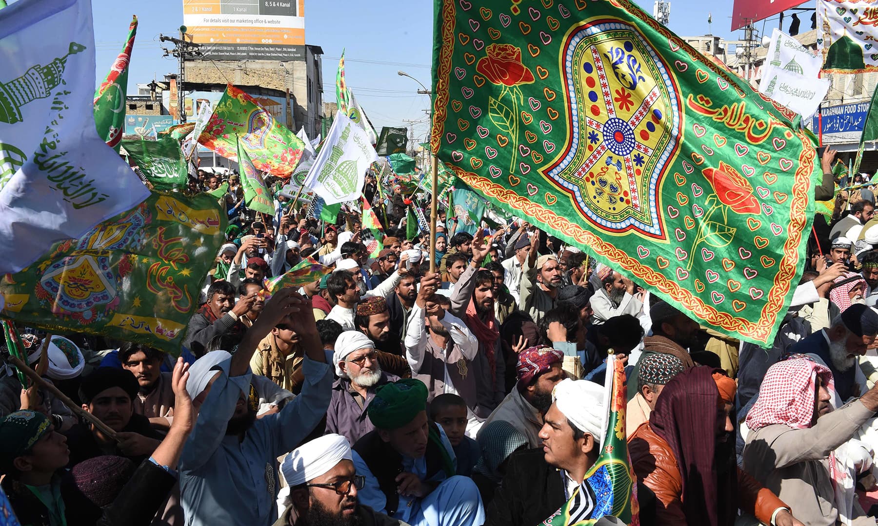 Participants carry flags as they march in a procession o celebrate the birth of the Holy Prophet (PBUH), in Karachi on Sunday. — AFP