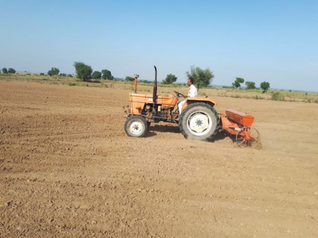 A farmer sows wheat near Chakwal. — Dawn