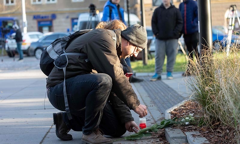 A man lights a candles in front of the Faculty Hospital in Ostrava, eastern Czech Republic on December 10, after a gunman opened fire on the morning, killing six people.  — AFP