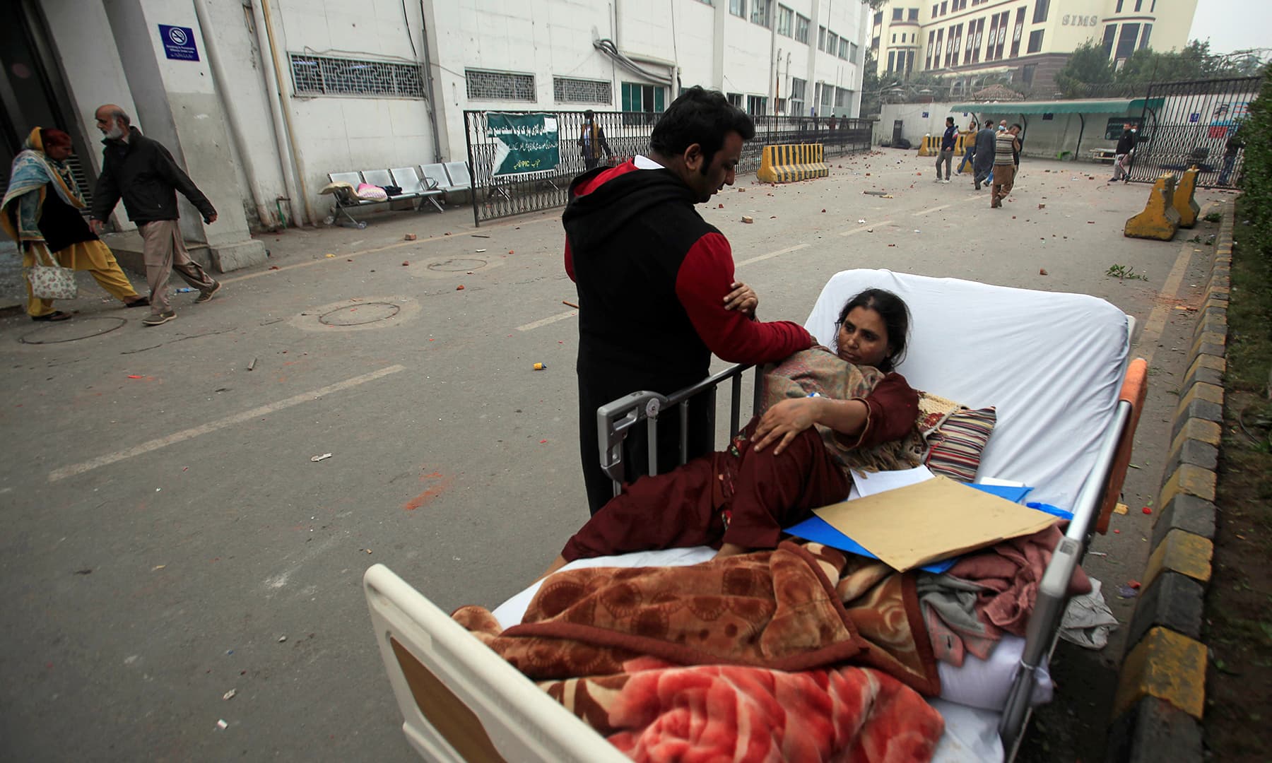 A relative takes care of a patient on a bed after she was taken out of her ward when a group of lawyers stormed the PIC. — Reuters