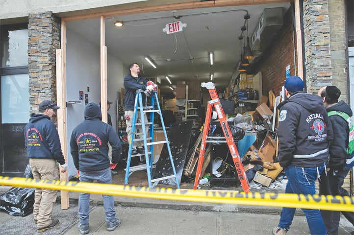 JERSEY CITY: People working at the site of the attack on Wednesday.&mdash;AP
