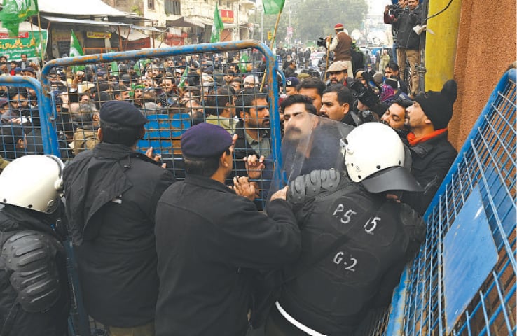 PML-N workers scuffle with police outside FIA offices on Temple Road. — White Star