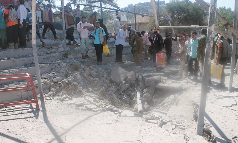 AL DHALEA: Passers-by look at the scene of the blast.&mdash;Reuters