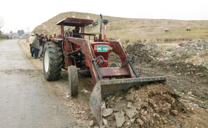 A tractor levels ground in Khar on Friday. — Dawn