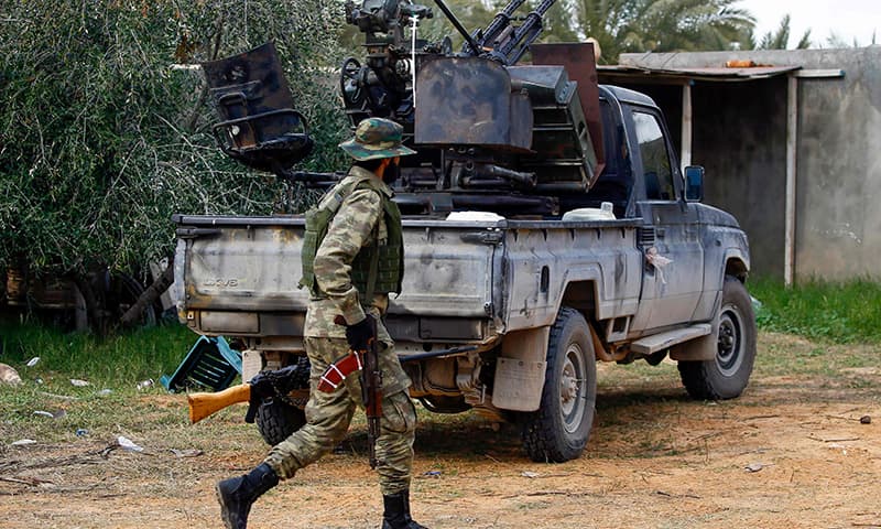 A fighter loyal to the internationally recognised Libyan Government of National Accord (GNA) walks past a vehicle in an area south of the Libyan capital Tripoli on January 12. — AFP A fighter loyal to the internationally recognised Libyan Government of National Accord (GNA) walks past a vehicle in an area south of the Libyan capital Tripoli on January 12. — AFP
