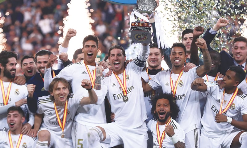 Sergio Ramos lifts the trophy as Real Madrid players celebrate winning the Spanish Super Cup final against Atletico Madrid at the King Abdullah Sports City.&mdash;Reuters
