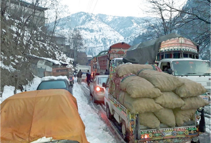 Traffic comes to a halt in Alpuri Bazaar, Shangla, on Wednesday due to heavy snowfall. — Dawn