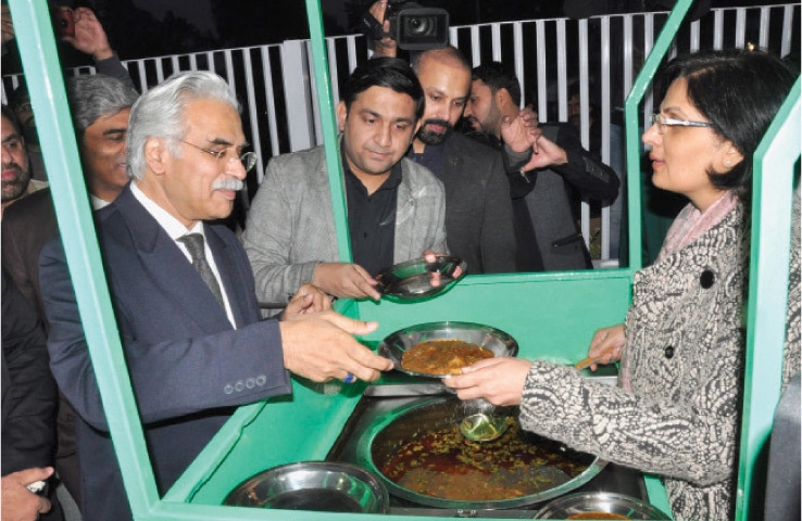 Dr Sania Nishtar gives food to Special Assistant to the Prime Minister on Health Dr Zafar Mirza at the Langar inaugurated at Pims on Friday. — White Star