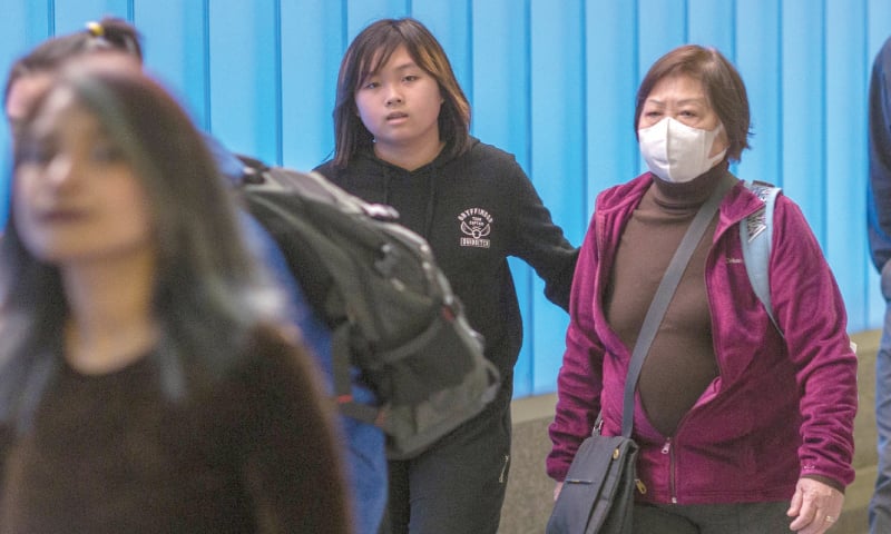 A woman arriving on an international flight to Los Angeles International Airport wears a mask on the first day of health screenings for coronavirus of travelers from Wuhan in China.—AFP