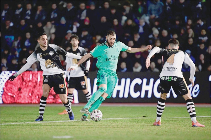 SALAMANCA (Spain): Real Madrid&rsquo;s Karim Benzema (C) vies with Unionistas&rsquo; Inigo Zubiri (R) during their Copa del Rey match at the Las Pistas del Helmantico Stadium.&mdash;AFP