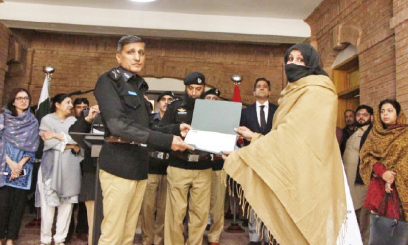 KP police chief Sanaullah Abbasi hands over certificate to a police officer during a function in Peshawar on Friday.