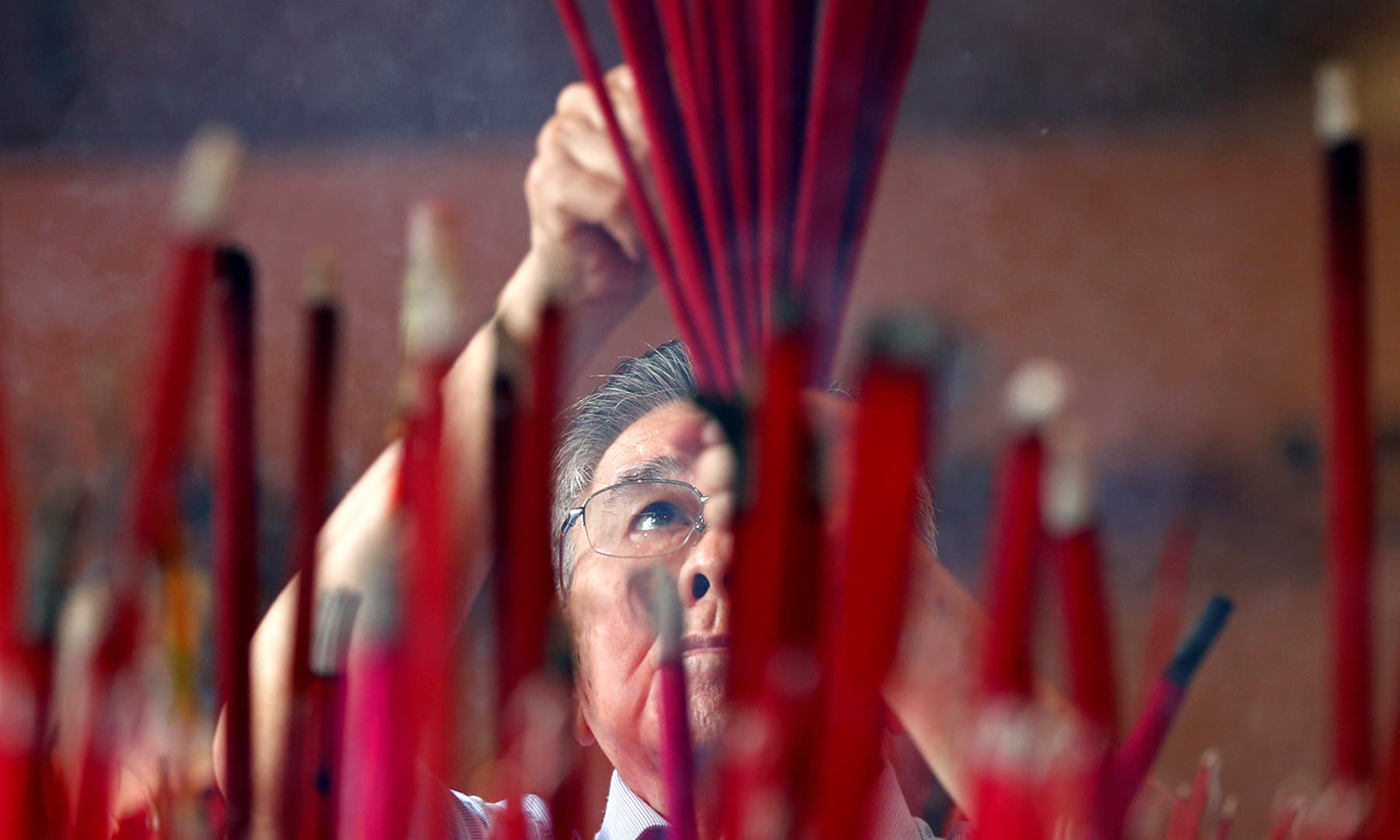 A man prays during Chinese Lunar New Year celebrations at a temple in Jakarta, Indonesia on January 25, 2020. — Reuters