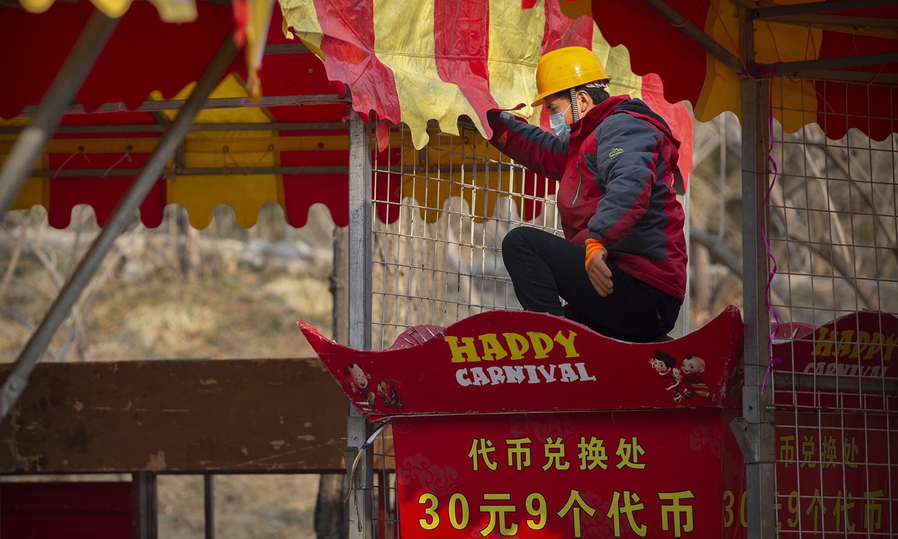 A worker dismantles a carnival built for a canceled Lunar New Year temple fair at Longtan Park in Beijing on January 25, 2020. — AP