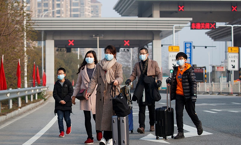 People who said they arrived from Hubei province after passing a checkpoint at the Jiujiang Yangtze River Bridge, head to the train station in Jiujiang, Jiangxi province, China, as the country is hit by an outbreak of a new coronavirus, on January 31. — Reuters