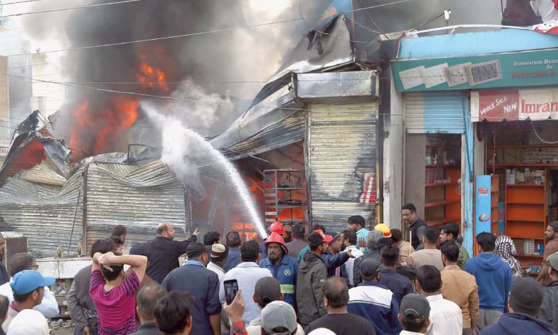 TRADERS try to salvage goods from their shops amid firefighters&rsquo; attempts (below) to douse the inferno in a Malir locality on Tuesday.&mdash;PPI