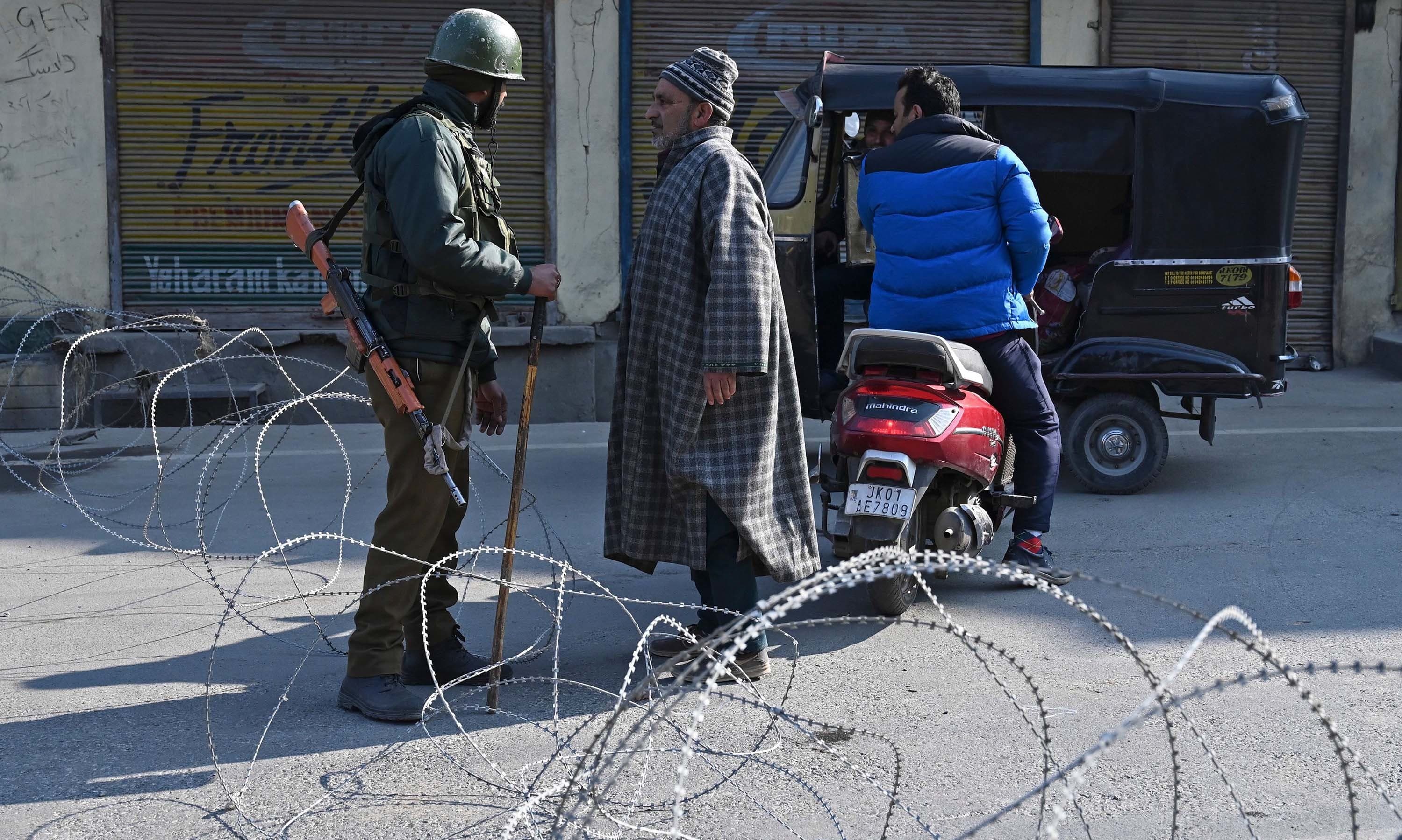 An Indian paramilitary trooper talks to a man at a checkpoint during a one-day strike called by Jammu and Kashmir Libration Front (JKLF) to demand the return of the remains of Afzal Guru, who was executed in 2013 over the Indian parliament attack in 2001, in downtown  Srinagar in occupied Kashmir on February 9. — AFP