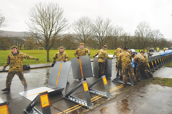 Members of the 4th Battalion Yorkshire Regiment erect flood barricades in Ilkley, West Yorkshire, on Saturday as Storm Dennis sweeps in over the country.—AFP