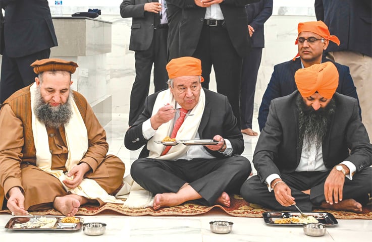 United Nations Secretary General Antonio Guterres eats food along with Minister for Religious Affairs Noorul Haq Qadri during his visit to the Baba Guru Nanak Dev shrine at Gurdwara Darbar Sahib in Kartarpur on Tuesday.—AFP