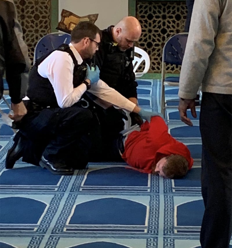 Police officers handcuff a man inside the London mosque. — Courtesy @MurshHabib Twitter