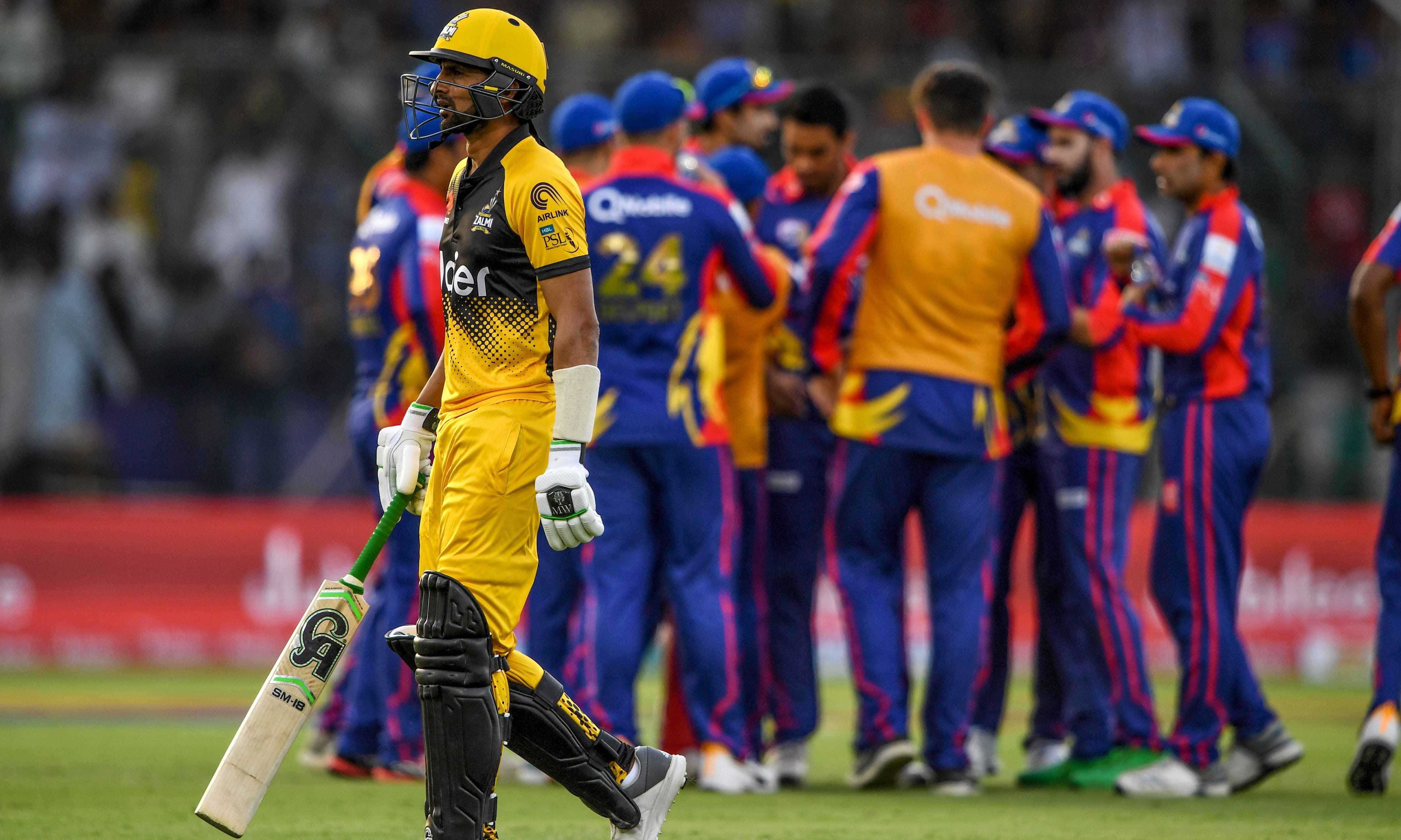 Peshawar Zalmi's Shoaib Malik (L) walks back to the pavilion after his dismissal during the Pakistan Super League (PSL) Twenty20 cricket match between Peshawar Zalmi and Karachi Kings at the National Cricket Stadium on Feb 21. — AFP