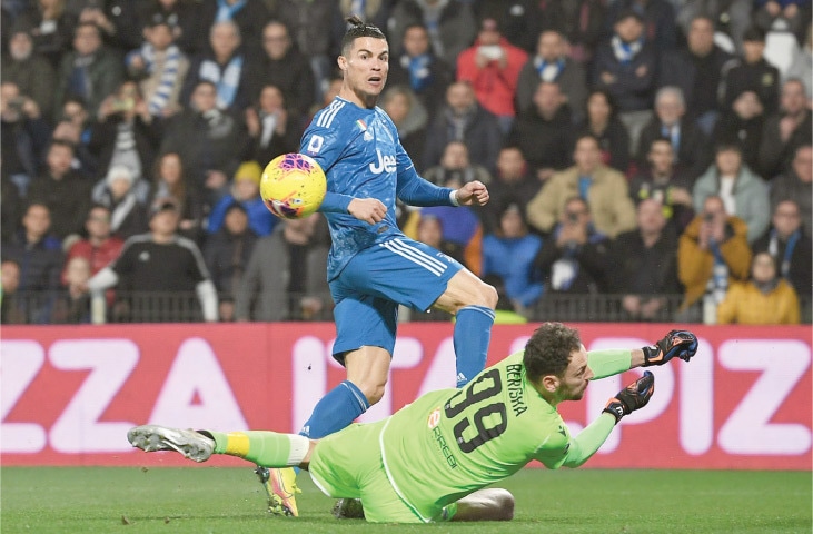 FERRARA: Juventus’ Cristiano Ronaldo chips the ball past SPAL goalkeeper goalkeeper Etrit Berisha to score during their Serie A match at the Paolo-Mazza Stadium.—AFP