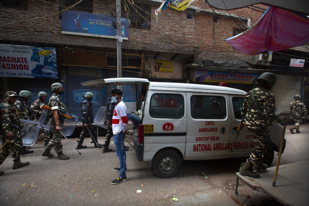 Indian paramilitary force soldiers patrol on Wednesday as an ambulance stationed at the area which witnessed Tuesday's violence in New Delhi, India. ─ AP