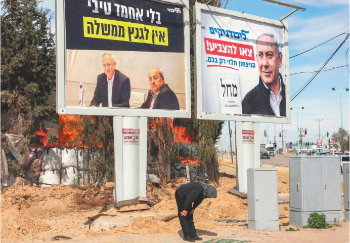 BEERSHEBA: A Bedouin prays along a road in this southern Israeli city, with Likud party electoral posters serving as the backdrop. The poster on the right shows Israeli Prime Minister Benjamin Netanyahu with text in Hebrew reading “Likudniks, go vote, victory depends only on you”. The other shows retired army general Benny Gantz of the rival alliance sitting with Arab parliament member Ahmad Tibi with text reading “Gantz has no government without Tibi”.—AFP