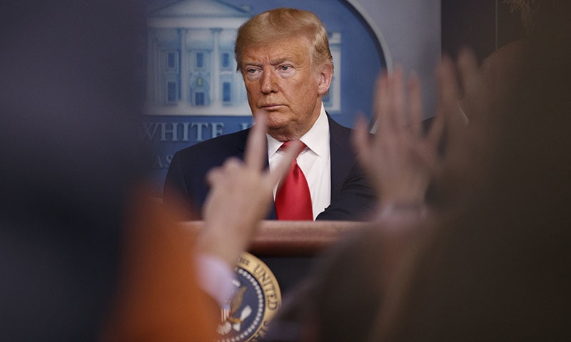 As reporters raise their hands, President Donald Trump pauses as he speaks about the coronavirus in the press briefing room at the White House on Saturday. — AP