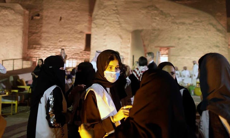 A Saudi tour guide wears a mask, due to the coronavirus, in front of the historical Salwa Palace, in Diriyah, outside Riyadh, Saudi Arabia. — AP