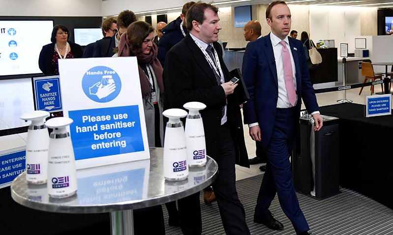 Britain's health minister Matt Hancock walks past a hand sanitising station as he leaves a conference venue in London, Britain. &mdash; Reuters