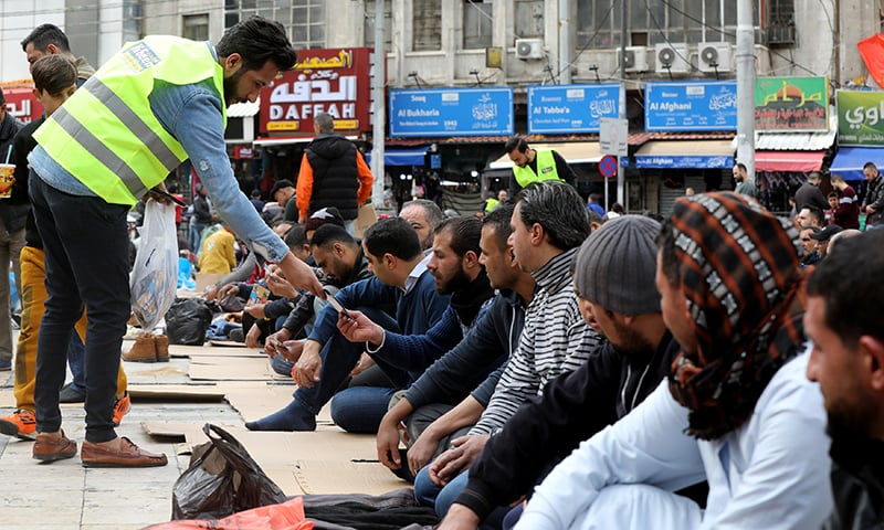 A staff member from sanitizing company distributes hand sanitiser for free for worshippers during Friday prayers outside al Husseini mosque in downtown Amman, Jordan on March 6, 2020. &mdash; Reuters