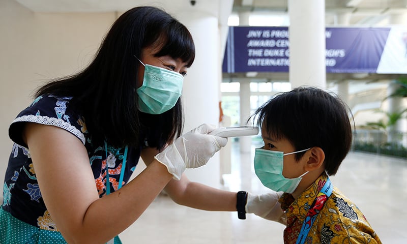 A teacher checks a student with thermal scanner at school after Indonesia confirmed its first cases of coronavirus disease (COVID-19), in Tangerang near Jakarta, Indonesia on March 6, 2020. &mdash; Reuters