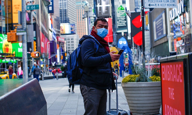 A man visits Times Square as he wears a face mask on March 8, 2020 in New York City. The governor of New York on March 7, 2020 announced a state of emergency as the coronavirus continued to spread in the northeastern state. — AFP