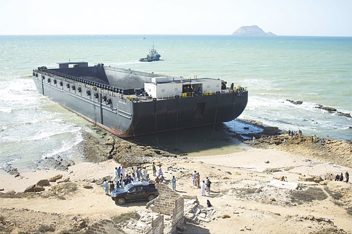 KARACHI: A vessel carrying coal cargo is pictured after it ran aground near Mubarak Village on Wednesday. The ship ran aground after big sea waves steered it from its route towards a rocky surface of the beach in the morning.—PPI