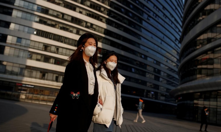 Women wears face masks outside an office complex in Beijing as the country is hit by an outbreak of the novel coronavirus. — Reuters