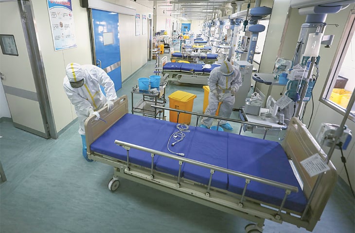 WUHAN: A medical worker moves a bed at a hospital ward which used to be an isolation ward for COVID-19 patients. —AFP