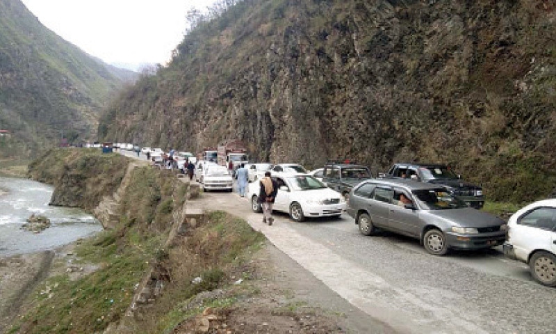Motorists wait for reopening of road blocked by protesters in Ranyal, Shangla, on Friday. &mdash; Dawn