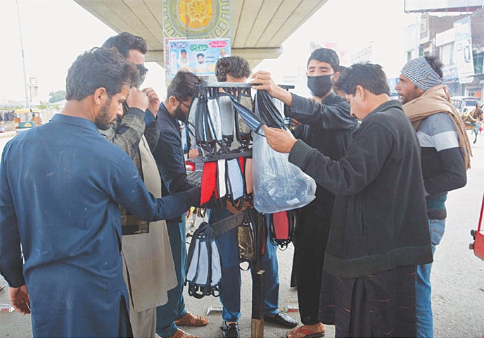 In Gujranwala, people buy face masks.